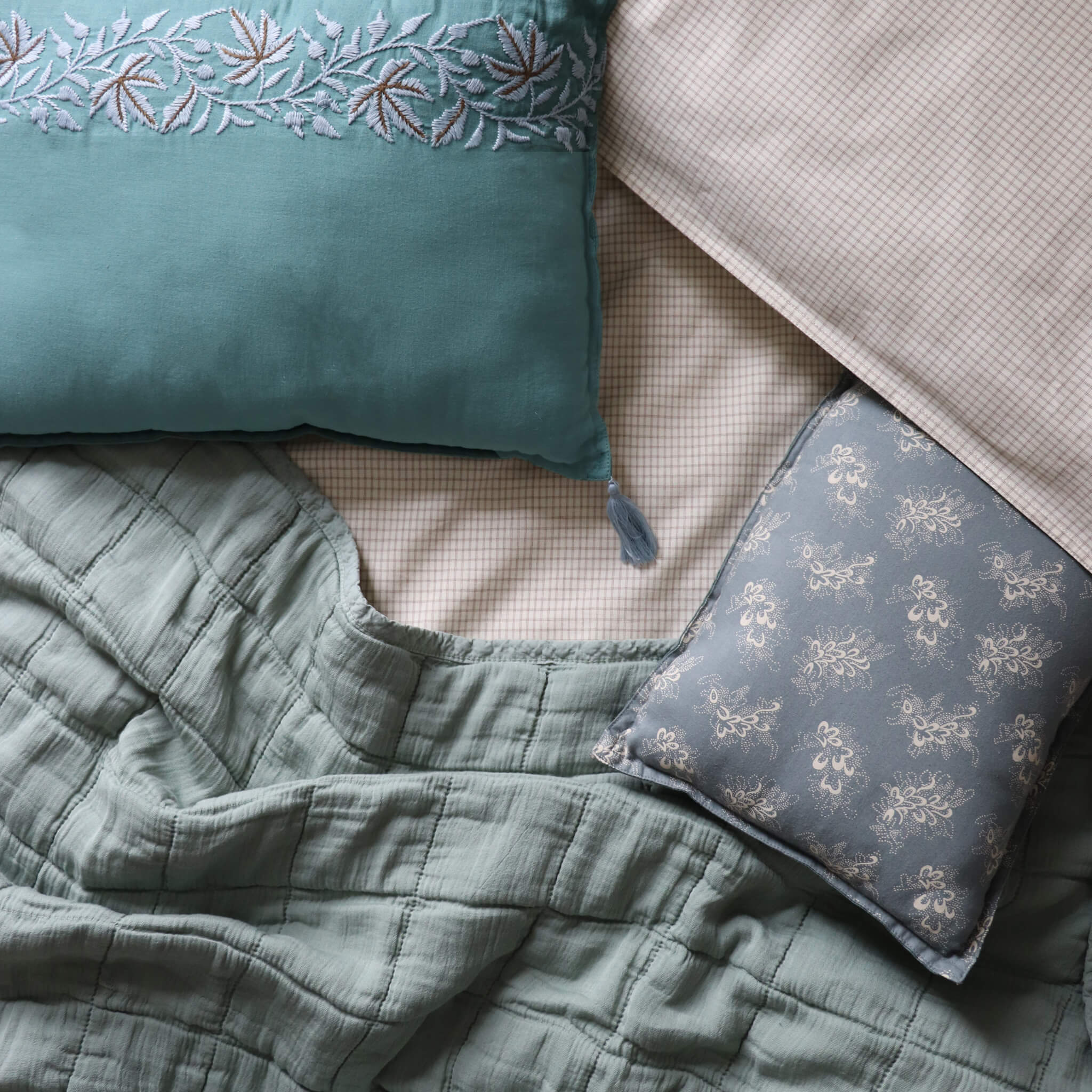 Square quilted blanket in sage 100% soft cotton gauze and lightly filled with anti-allergy polyester comes in 4 different sizes and can be mixed with our beautiful Celia print bedding in soft blue and stone by camomile london