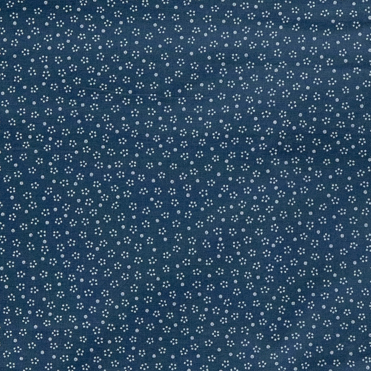 A close up of a print with an indigo base and small off white ditsy dot printed on top.
